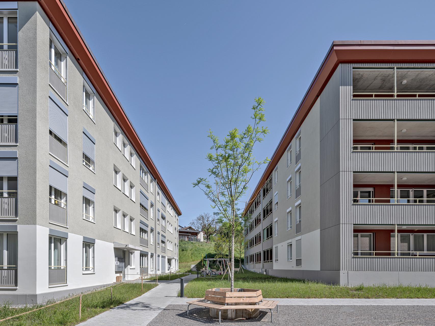 Mitten im historischen Zentrum von Steffisburg, gut abgeschirmt nur 80 Meter neben der Dorfstrasse, hat HRS vier Mehrfamilienhäuser mit total 89 Mietwohnungen und Gewerbeflächen realisiert. Mit dem Neubau auf dem grösstenteils unbebauten Areal wurde einem Wunsch der Gemeinde nach innerer Verdichtung entsprochen.Mitten im historischen Zentrum von Steffisburg, gut abgeschirmt nur 80 Meter neben der Dorfstrasse, hat HRS vier Mehrfamilienhäuser mit total 89 Mietwohnungen und Gewerbeflächen realisiert. Mit dem Neubau auf dem grösstenteils unbebauten Areal wurde einem Wunsch der Gemeinde nach innerer Verdichtung entsprochen. KONZEPT/ARCHITEKTUR Drei grössere und ein kleineres Gebäude sowie Grün- und Freiflächen machen die hindernisfreie Überbauung zu einem ansprechenden Wohnquartier im Zentrum von Steffisburg. Dank der ästhetisch ausgewählten Materialien für die Aussenhülle fügen sich die Neubauten nahtlos ins Bild des historischen Dorfkerns ein. Die grossflächigen Holzverschalungen wirken im Zusammenspiel mit den zwei unterschiedlich farbigen Verputzflächen zeitlos und dennoch stilvoll. Für Luft zwischen den leicht versetzt angeordneten, vierstöckigen Wohnbauten sorgen auch die innenliegenden Loggias – sie harmonieren perfekt mit der geradlinigen, aufgeräumten und attraktiven Gestaltung des Quartiers. Mit ihren grosszügigen Aussenräumen weisen die Kleinwohnungen eine hohe Qualität auf. Die unterschiedlichen Wohnungstypen richten sich mehrheitlich auf zwei oder mehr Fassaden aus. Die Überbauung wurde in Massivbauweise erstellt. Die vier Gebäude stehen auf einem Untergeschoss, während sich dazwischen eine Tiefgarage für 73 Abstellplätze erstreckt. Die Fassade besteht aus einer Kompaktfassade nach Minergie® P-Standard mit einem robusten mineralischen Putz. Die Balkonschichten werden mit einer Holzschalung akzentuiert und erinnern an die Lauben der Umgebung. ENERGIEKONZEPT/NACHHALTIGKEIT Die Überbauung Scheidgasse erfüllt die strengen Vorgaben von Minergie-P®; auf eine Zertifizierung wurde jedoch verzichtet. Auf allen vier Gebäuden wird mit Photovoltaikanlagen eigener Strom produziert. Insgesamt erzielen die Photovoltaikanlagen eine Leistung von 340 Wp.Die Wärmeenergie liefert die NetZulg AG: Das Fernwärmenetz aus Steffisburg produziert die Energie hauptsächlich mit Abwärme aus der Kehrichtverbrennungsanlage sowie mit einem Blockheizkraftwerk.