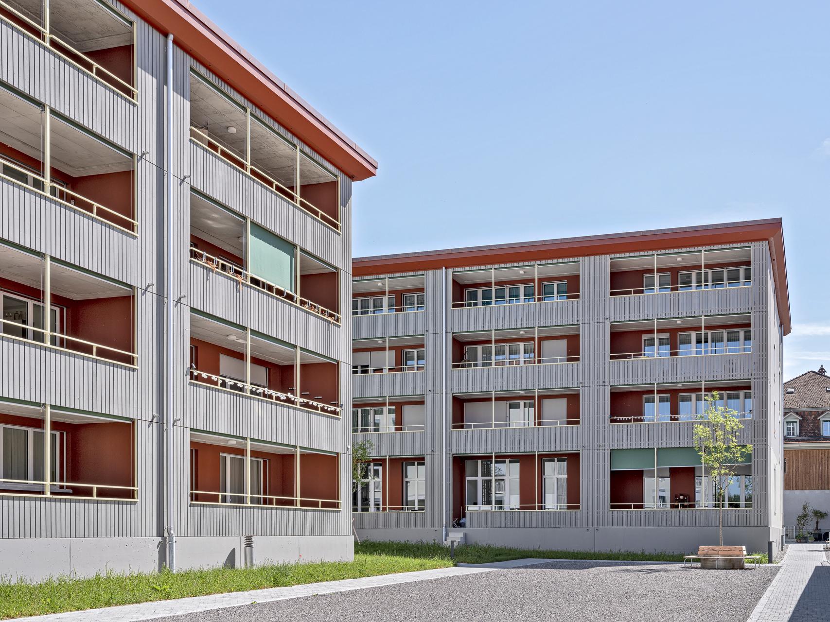 Mitten im historischen Zentrum von Steffisburg, gut abgeschirmt nur 80 Meter neben der Dorfstrasse, hat HRS vier Mehrfamilienhäuser mit total 89 Mietwohnungen und Gewerbeflächen realisiert. Mit dem Neubau auf dem grösstenteils unbebauten Areal wurde einem Wunsch der Gemeinde nach innerer Verdichtung entsprochen.Mitten im historischen Zentrum von Steffisburg, gut abgeschirmt nur 80 Meter neben der Dorfstrasse, hat HRS vier Mehrfamilienhäuser mit total 89 Mietwohnungen und Gewerbeflächen realisiert. Mit dem Neubau auf dem grösstenteils unbebauten Areal wurde einem Wunsch der Gemeinde nach innerer Verdichtung entsprochen. KONZEPT/ARCHITEKTUR Drei grössere und ein kleineres Gebäude sowie Grün- und Freiflächen machen die hindernisfreie Überbauung zu einem ansprechenden Wohnquartier im Zentrum von Steffisburg. Dank der ästhetisch ausgewählten Materialien für die Aussenhülle fügen sich die Neubauten nahtlos ins Bild des historischen Dorfkerns ein. Die grossflächigen Holzverschalungen wirken im Zusammenspiel mit den zwei unterschiedlich farbigen Verputzflächen zeitlos und dennoch stilvoll. Für Luft zwischen den leicht versetzt angeordneten, vierstöckigen Wohnbauten sorgen auch die innenliegenden Loggias – sie harmonieren perfekt mit der geradlinigen, aufgeräumten und attraktiven Gestaltung des Quartiers. Mit ihren grosszügigen Aussenräumen weisen die Kleinwohnungen eine hohe Qualität auf. Die unterschiedlichen Wohnungstypen richten sich mehrheitlich auf zwei oder mehr Fassaden aus. Die Überbauung wurde in Massivbauweise erstellt. Die vier Gebäude stehen auf einem Untergeschoss, während sich dazwischen eine Tiefgarage für 73 Abstellplätze erstreckt. Die Fassade besteht aus einer Kompaktfassade nach Minergie® P-Standard mit einem robusten mineralischen Putz. Die Balkonschichten werden mit einer Holzschalung akzentuiert und erinnern an die Lauben der Umgebung. ENERGIEKONZEPT/NACHHALTIGKEIT Die Überbauung Scheidgasse erfüllt die strengen Vorgaben von Minergie-P®; auf eine Zertifizierung wurde jedoch verzichtet. Auf allen vier Gebäuden wird mit Photovoltaikanlagen eigener Strom produziert. Insgesamt erzielen die Photovoltaikanlagen eine Leistung von 340 Wp.Die Wärmeenergie liefert die NetZulg AG: Das Fernwärmenetz aus Steffisburg produziert die Energie hauptsächlich mit Abwärme aus der Kehrichtverbrennungsanlage sowie mit einem Blockheizkraftwerk.